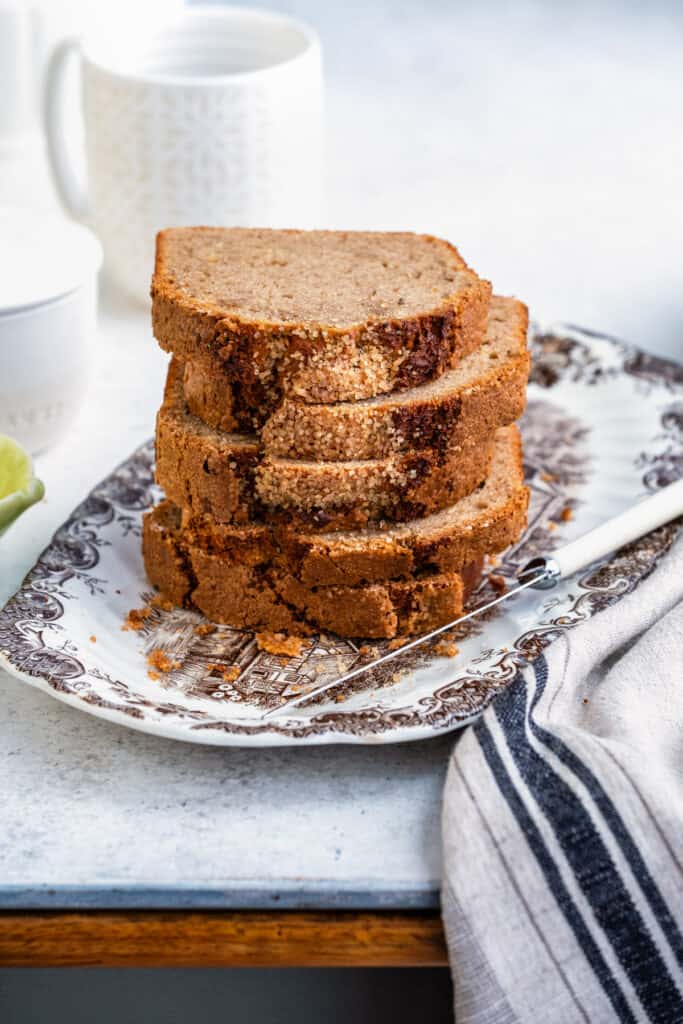 Banana loaf, sliced and stacked, on a plate