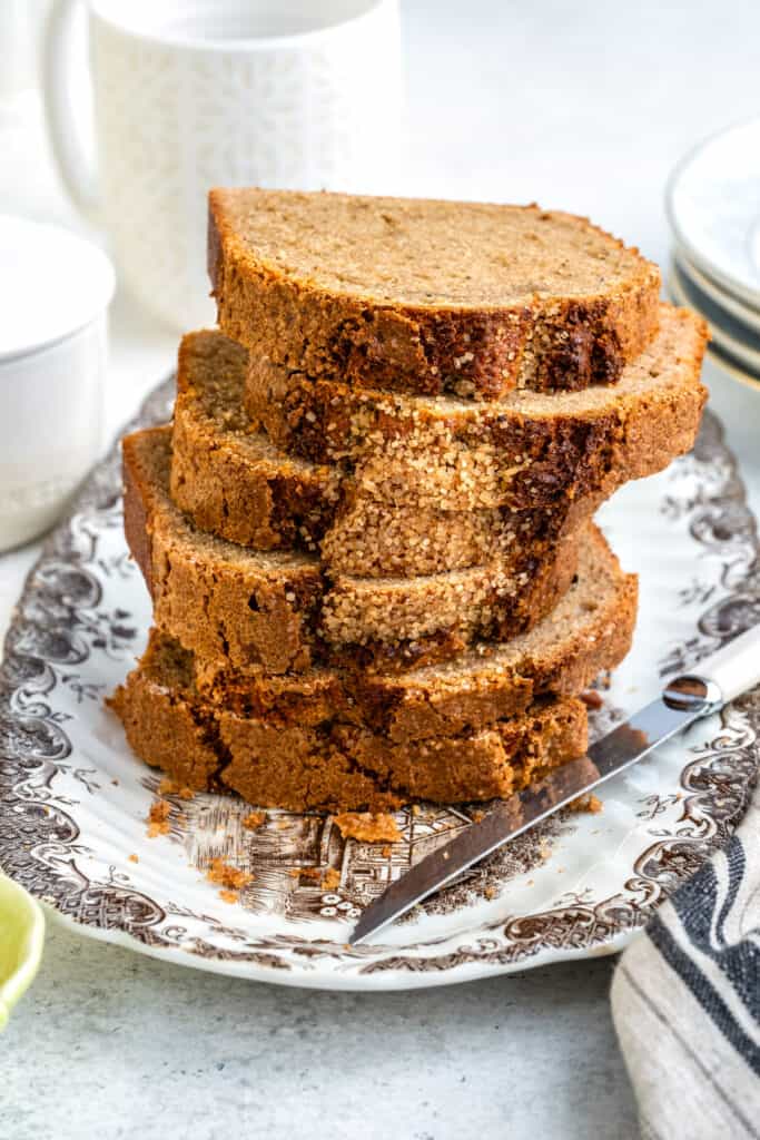 Slices of air fryer banana bread, stacked, on a patterned plate