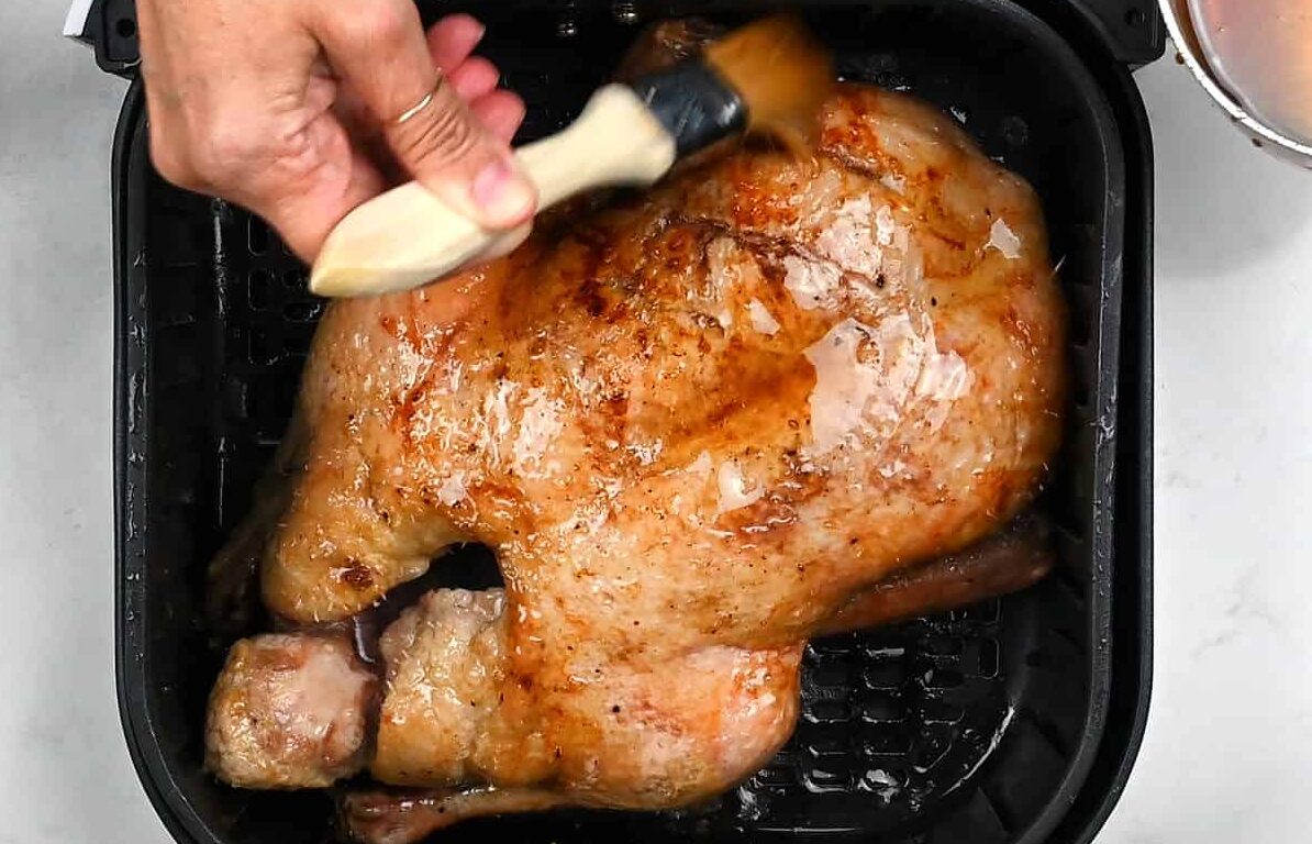 Brushing honey glaze over roast duck