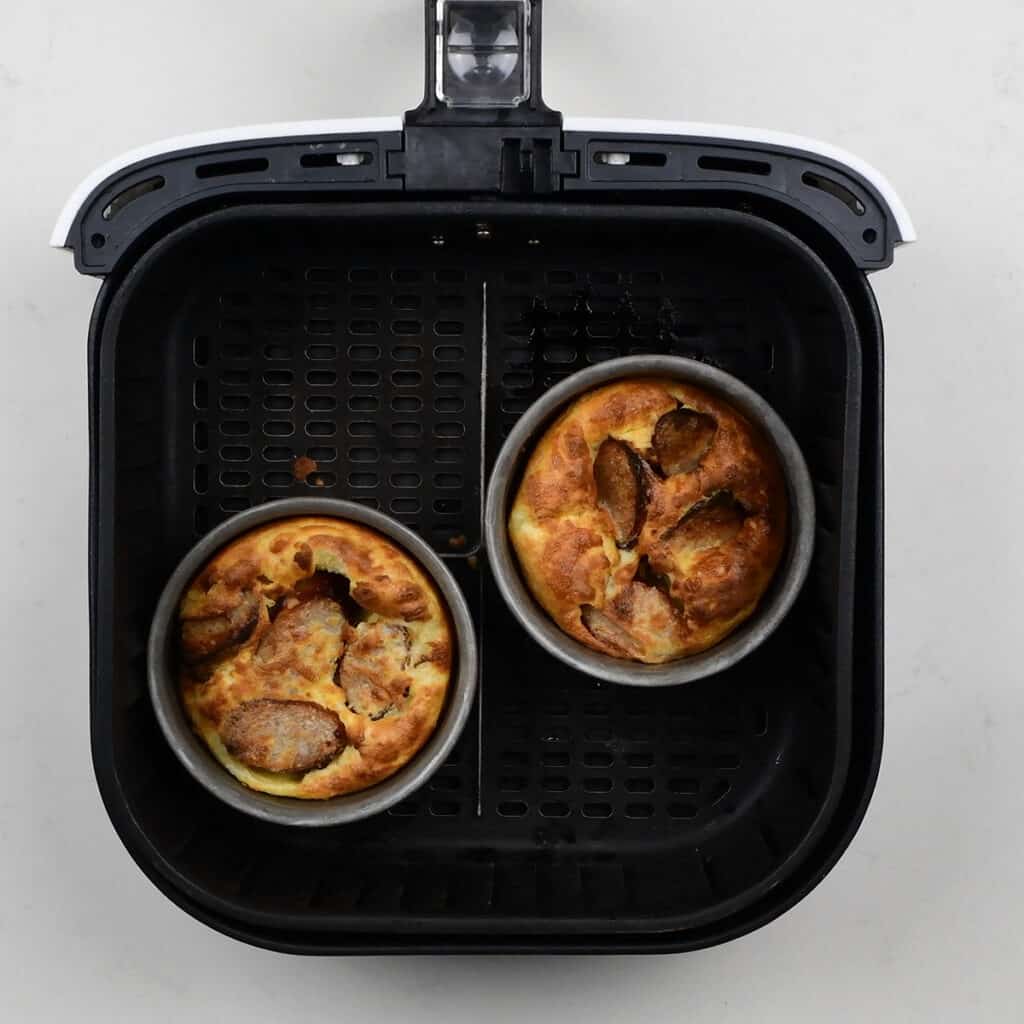 Two cake pans with toad in the hole  in a Cosori Air Fryer basket