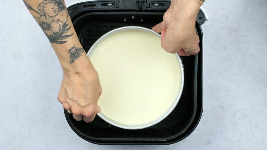 placing cheesecake pan in an air fryer basket