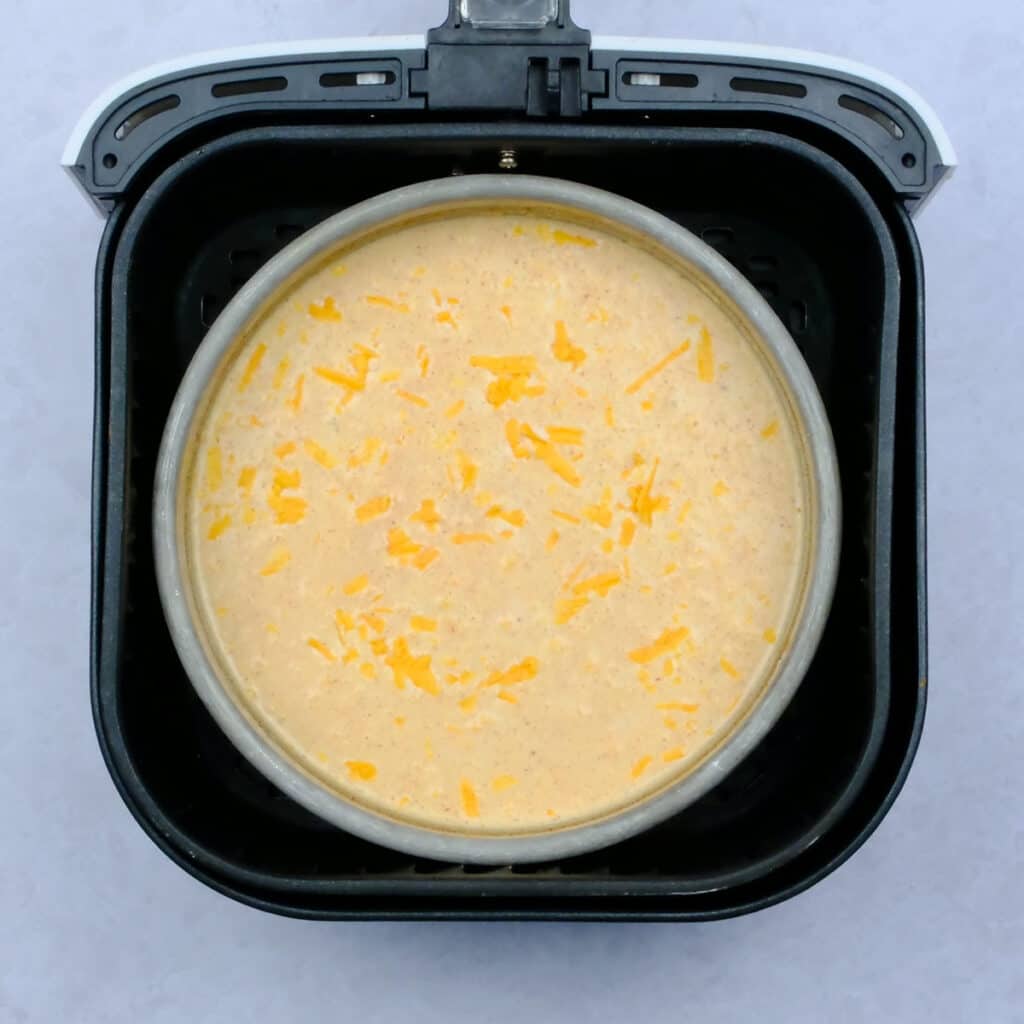 Pan with uncooked macaroni and cheese in an air fryer basket