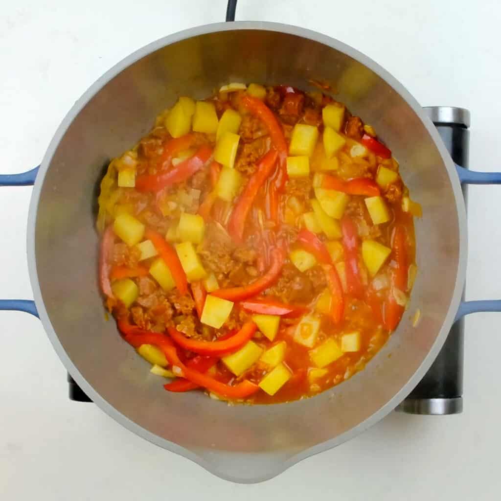 Peppers, onions, potatoes and chorizo simmering in a pot