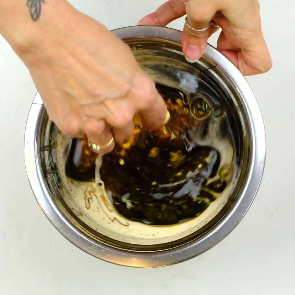 Stirring wet ingredients for Guinness brown bread in a metal bowl