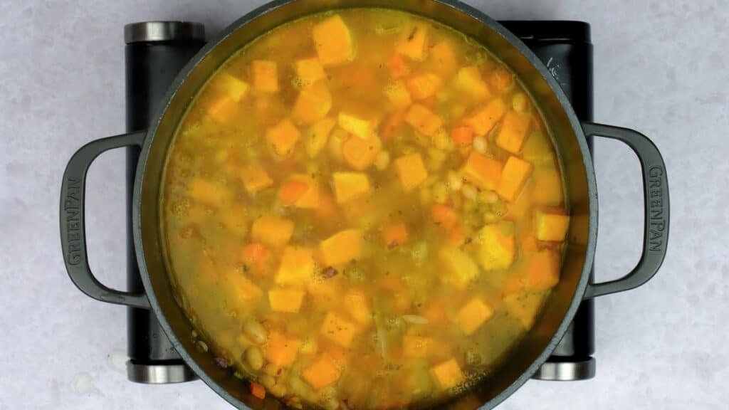 Vegetable orzo soup simmering in a large pot