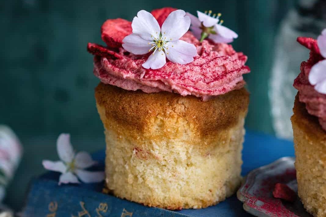 vanilla cupcakes with pink frosting and flowers