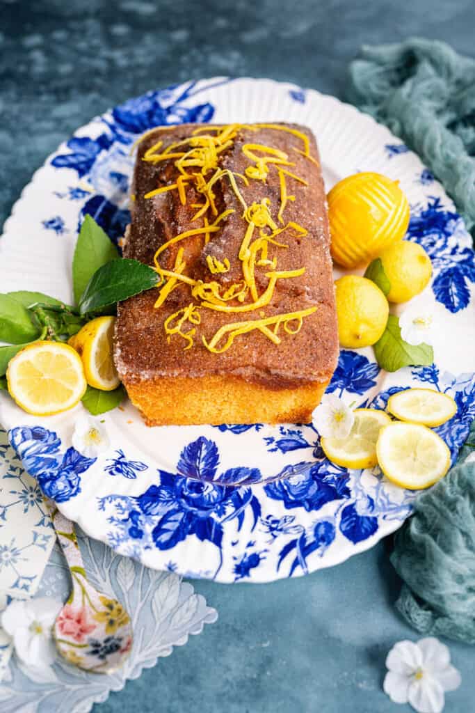 Small lemon drizzle cake on a patterned platter