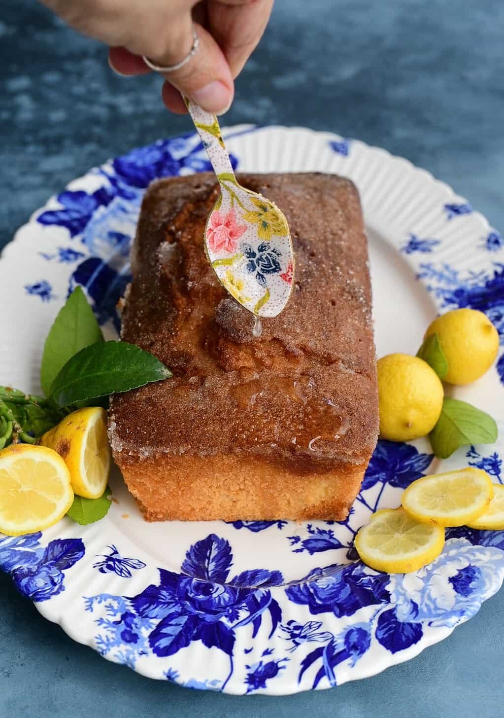Drizzling lemon syrup over air fryer lemon drizzle cake