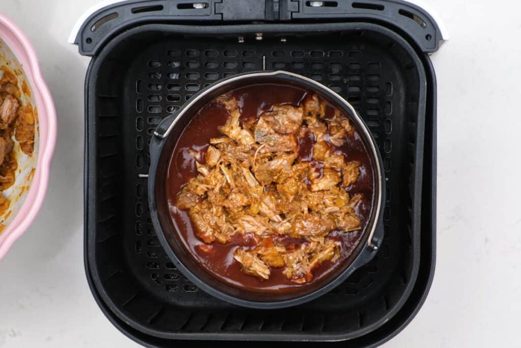 pulled pork in barbecue sauce in a deep cake pan in air fryer