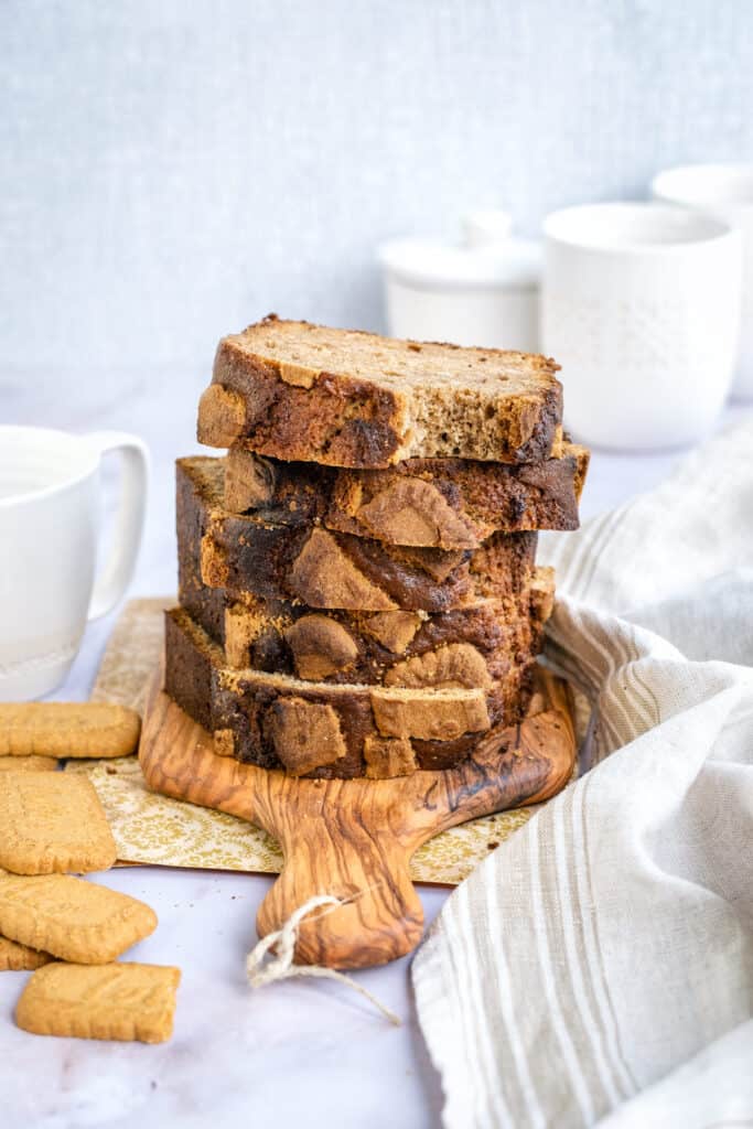 Biscoff Banana bread slices stacked on a small wooden board