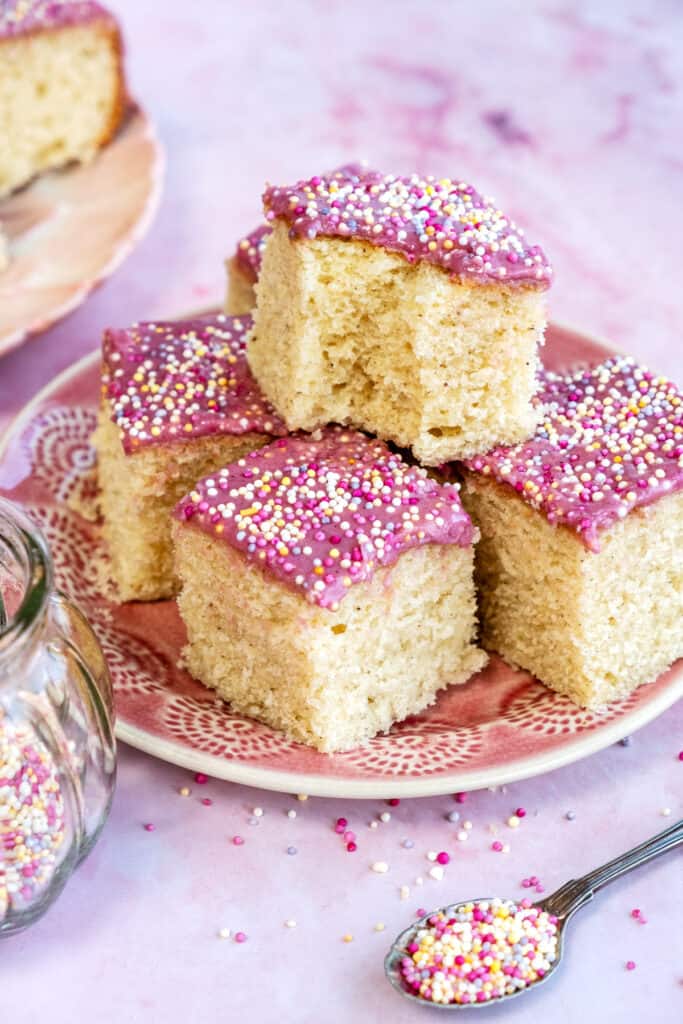 square slices of Air Fryer school cake with pink glaze and sprinkles