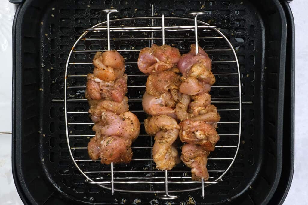 chicken skewers on a rack in air fryer basket