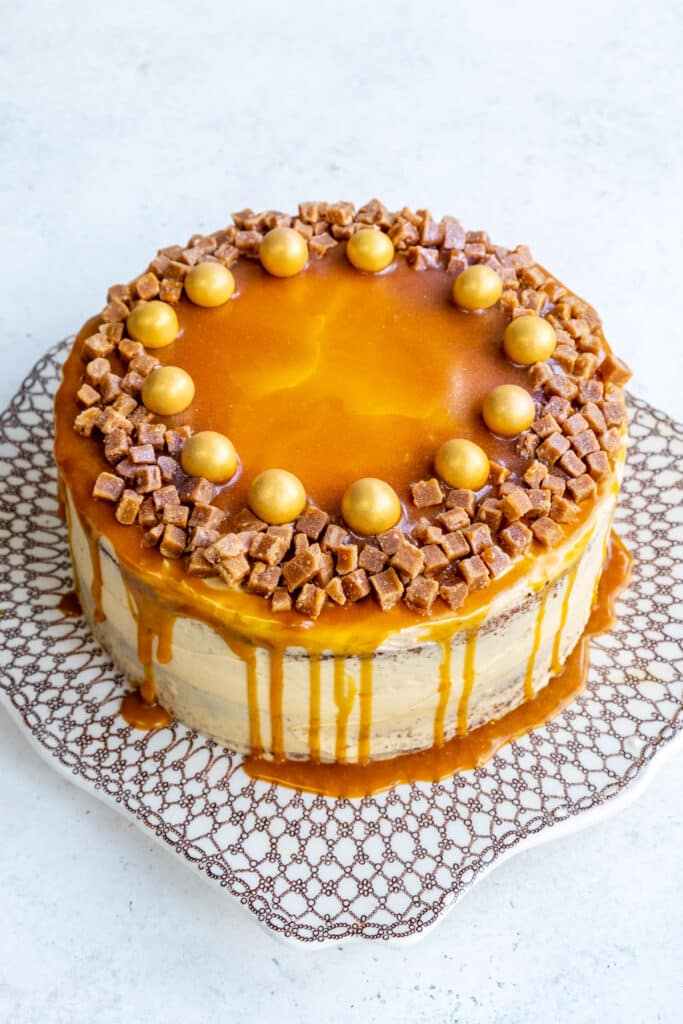 Salted caramel cake decorated with fudge pieces and large golden sprinkles