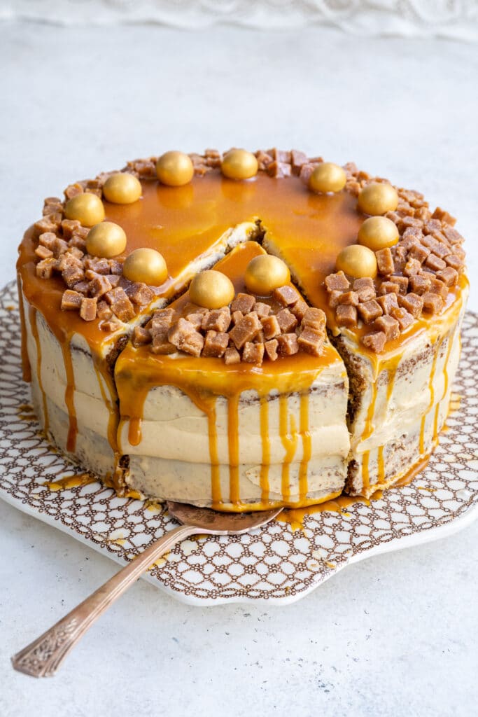 Mary Berry Salted Caramel cake on a patterned cake plate, one slice cut