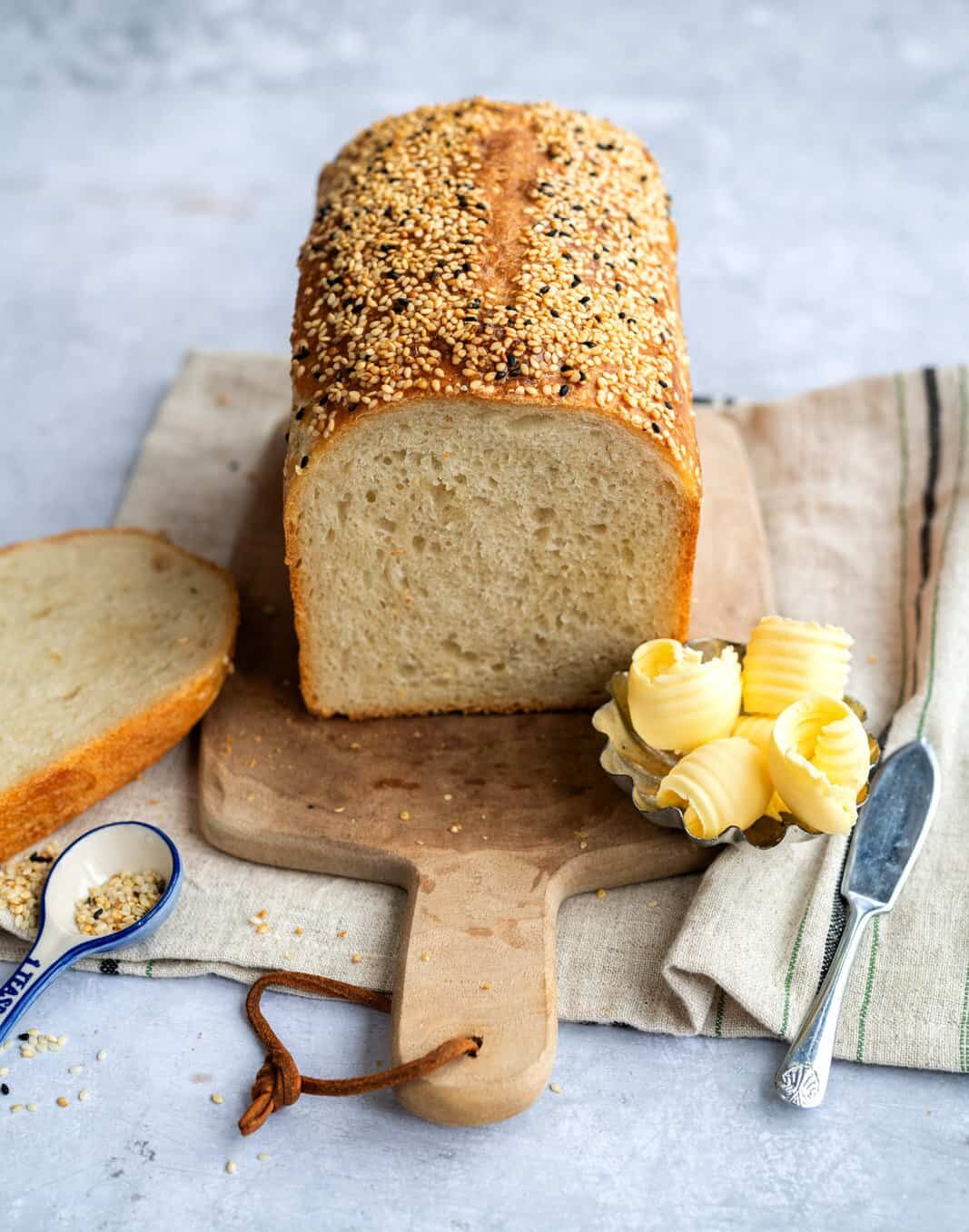 Sourdough Loaf with slice cut to show the crumb and butter on the side