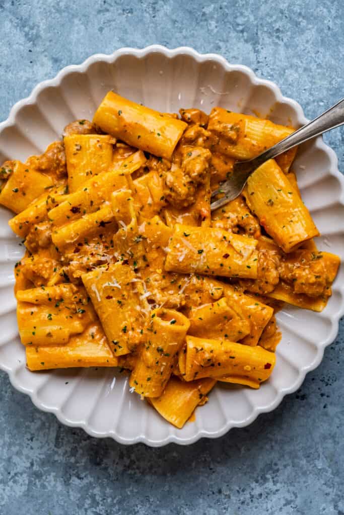 bowl serving of spicy rigatoni with sausage and creamy tomato sauce