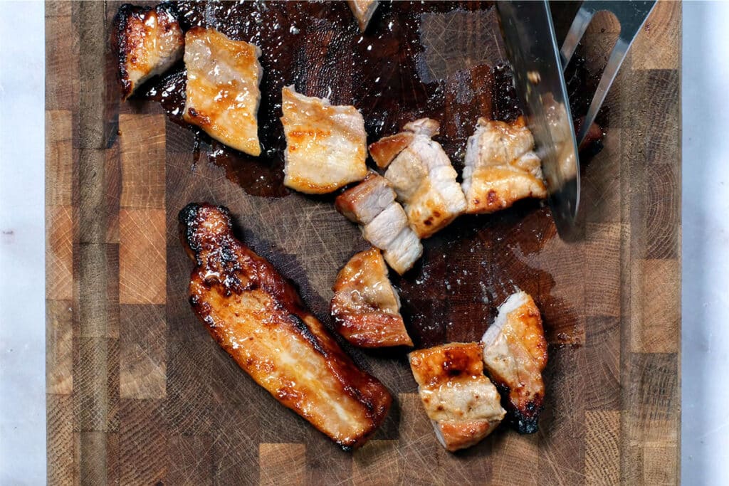 slicing pork belly on a wooden butcher block
