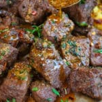 close up on air fryer steak bites drizzled with garlic butter