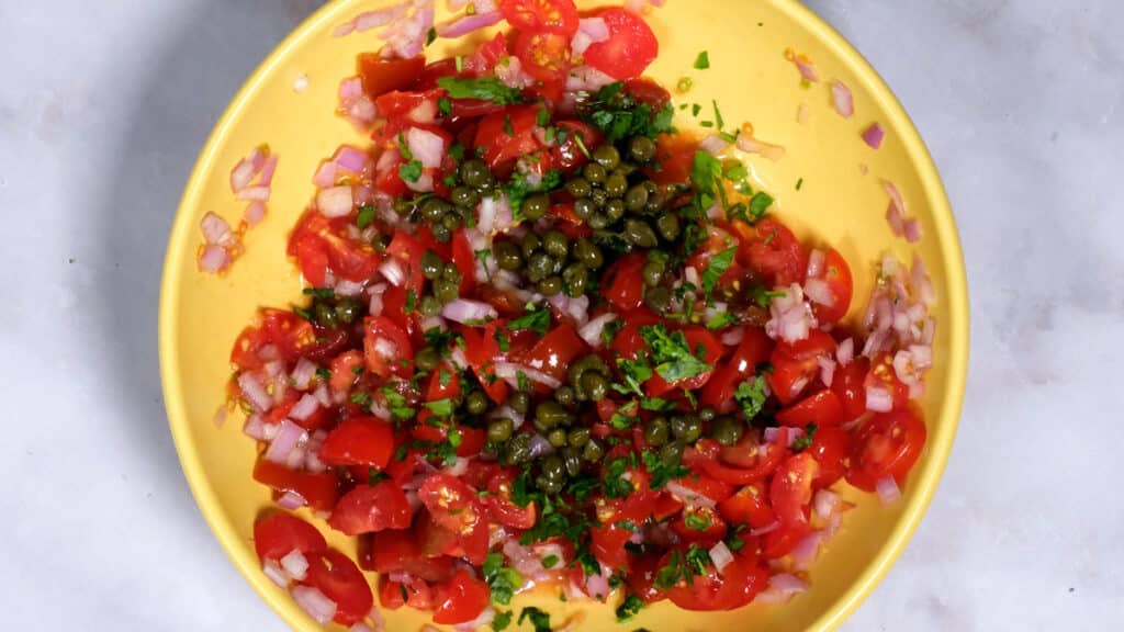 chopped tomatoes, shallots, capers, parsley in a bowl