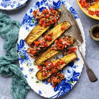 Thomas Keller's Viral Roasted Zucchini, cooked in an Air Fryer, on a platter topped with tomato sauce