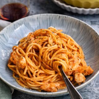 Bowl of spaghetti in a creamy tomato sauce with chicken and parmesan