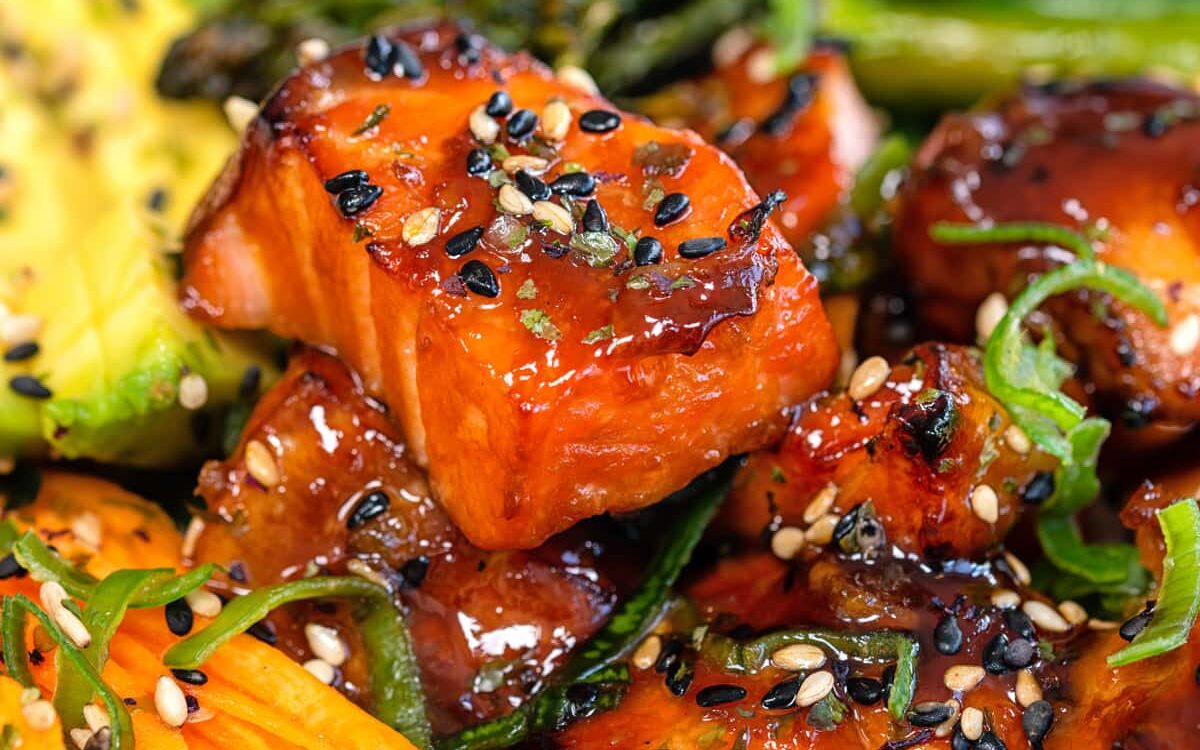 close up on air fryer salmon bites garnished with spring onions and sesame seeds