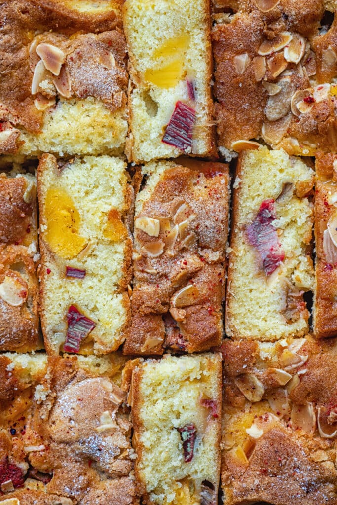 close up on slices of rhubarb custard cake, some on their side to show the interior texture