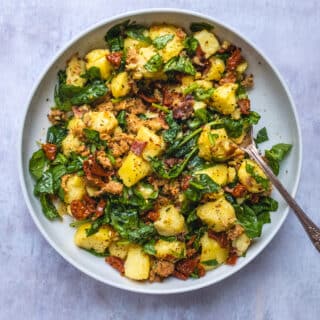 Warm potato salad with bacon, Italian sausage, sun dried tomatoes and spinach