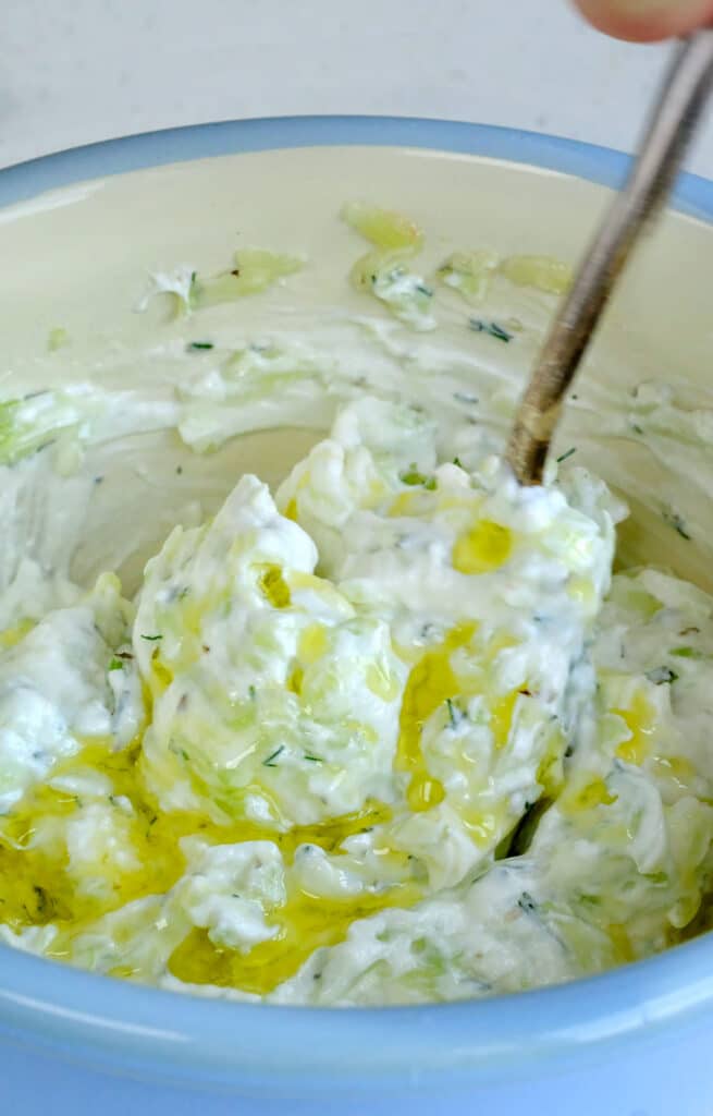 Creamy Greek yogurt sauce with cucumber and olive oil in a bowl