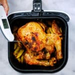Checking the internal temperature of air fryer chicken using a meat thermometer