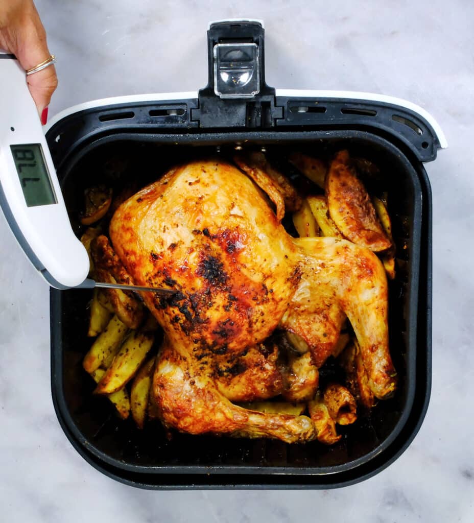 Checking the internal temperature of air fryer chicken using a meat thermometer