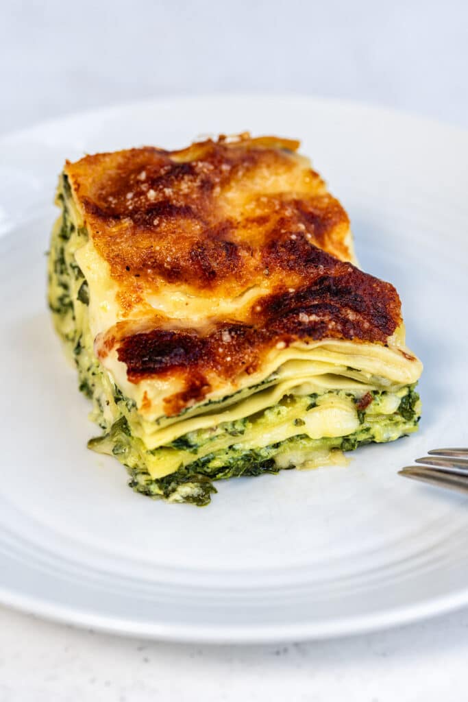 slice of air fryer lasagna with spinach and ricotta filling on a white plate