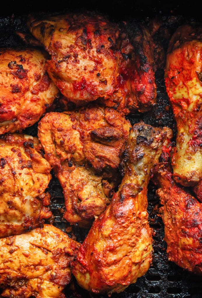 close up on air fryer tandoori chicken drumsticks and thighs