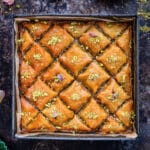 Greek baklava cut into a diamond pattern topped with chopped pistachions, top view