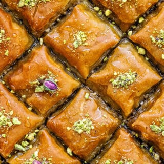 close up on a pan of sliced baklava topped with chopped nuts