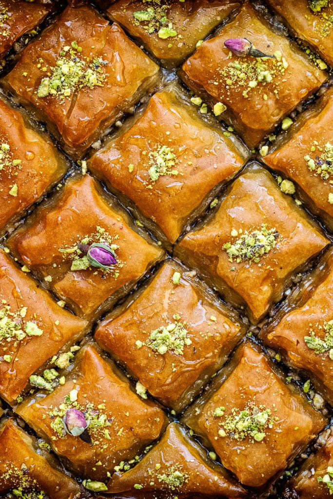 close up on a pan of sliced baklava topped with chopped nuts