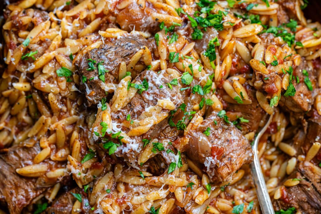 close up on beef stew with orzo pasta in tomato sauce
