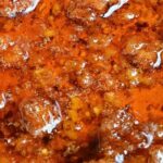 close up on sizzling oil with chorizo sausage, chili flakes, paprika