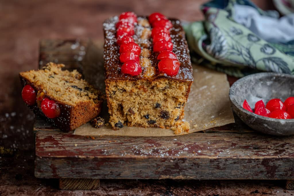 Mary Berry's Mincemeat Loaf Cake on a wooden board, one slice cut