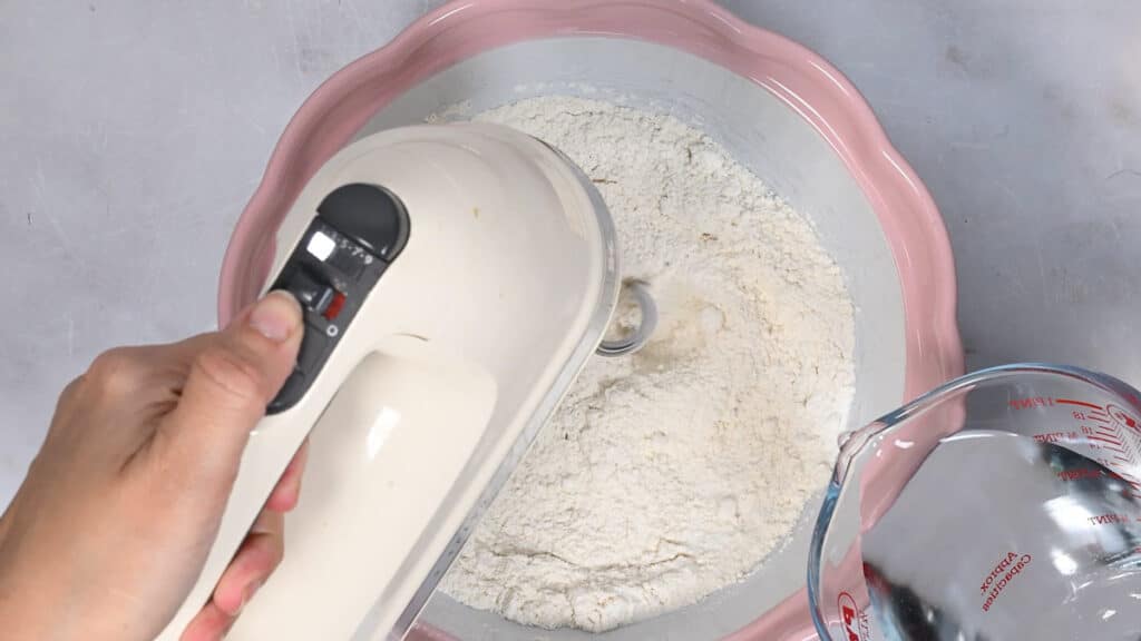 making salt dough in a bowl using a hand mixer