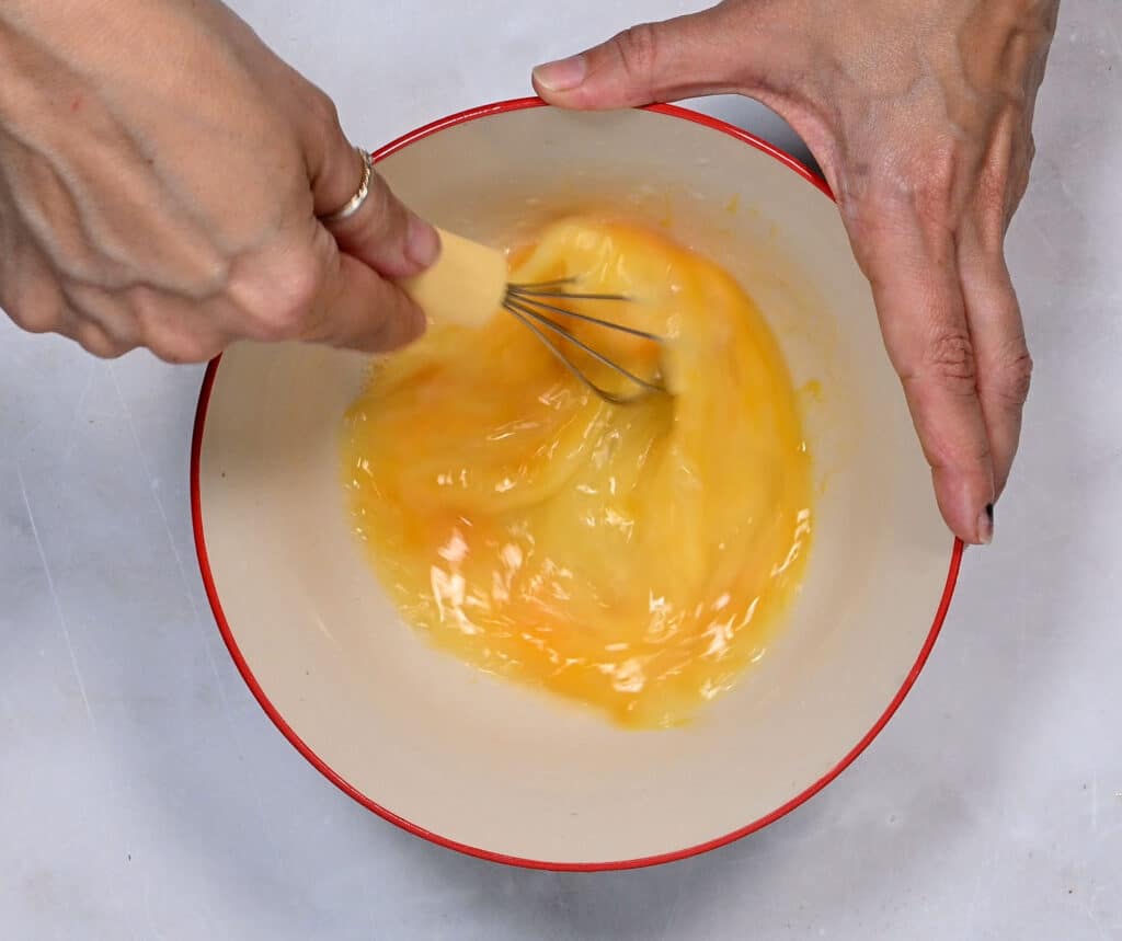 whisking eggs and lemon juice in a bowl