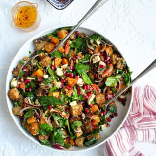 Roasted butternut squash salad with feta and pomegranate in a large white bowl