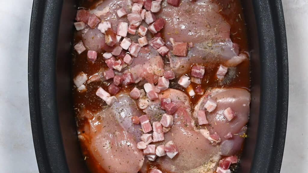 chicken thighs and bacon lardons in a crock pot insert