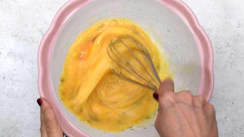 beating eggs in a mixing bowl