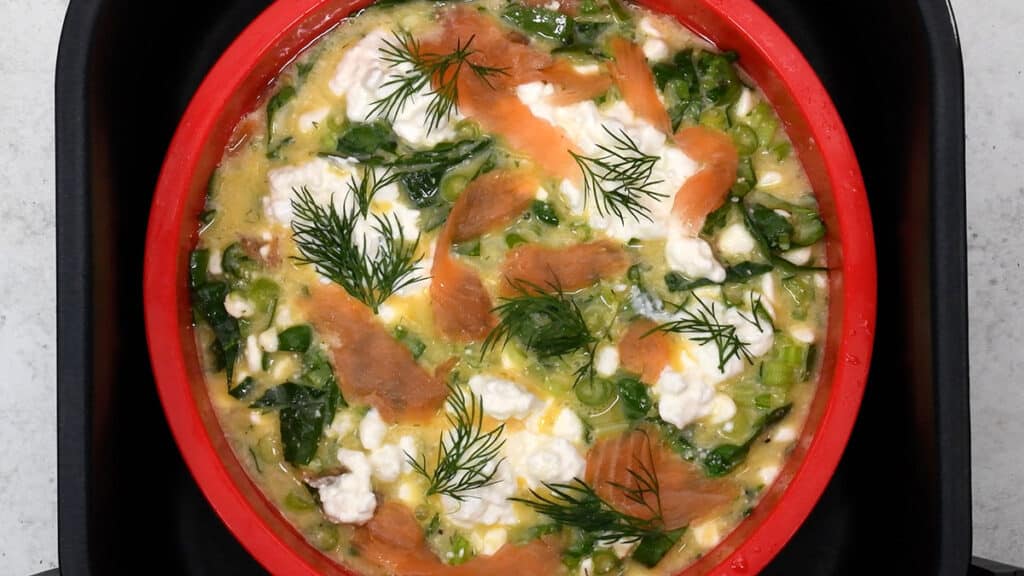 frittata in a silicone cake pan in the basket of an air fryer
