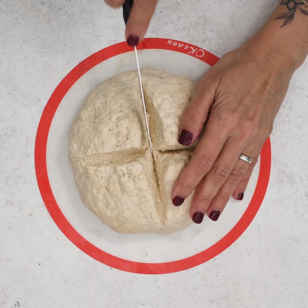 scoring the top of soda bread using a knife