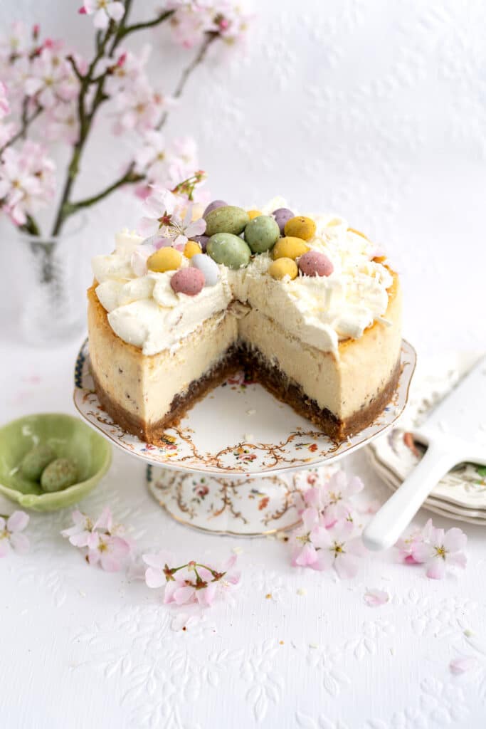 Easter Cheesecake on a cake stand with one large slice cut out 