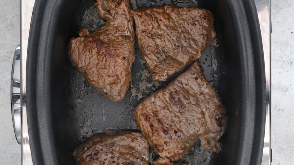 Browned braising steaks in a slow cooker