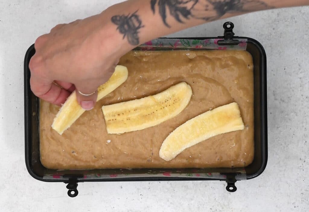 topping banana bread with sliced banana pieces