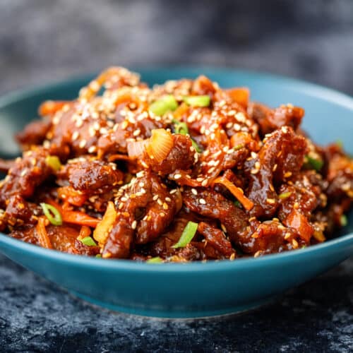 Serving of Air fryer Crispy Chilli beef in a blue bowl, side view